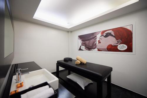 a bathroom with a sink and a painting on the wall at YOOMA Urban Lodge in Brussels