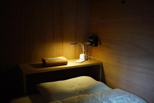a bedroom with a bed and a lamp on a wooden wall at La Union in Fukushima