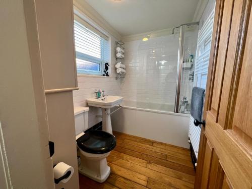 a bathroom with a toilet and a sink and a tub at Mill Cottage, New Refurbished, 2 Bed, Cleethorpes in Cleethorpes