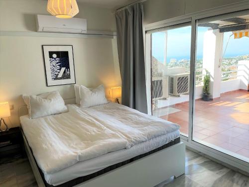 a bedroom with a large bed and a balcony at Sea View Riviera- 4 bed apartment in Riviera del Sol with beautiful sea view! in La Cala de Mijas
