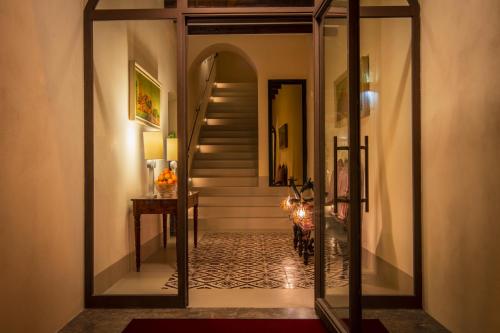 un pasillo con una puerta de cristal que conduce a una escalera en Palazzo Arone dei Baroni di Valentino, en Palermo