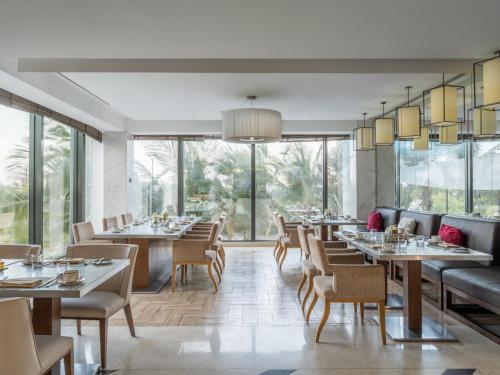 a restaurant with tables and chairs and large windows at The Venue Jeddah Corniche in Jeddah