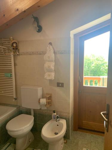 une salle de bain avec toilettes, lavabo et fenêtre dans l'établissement Maso Pallabazzer - Colle Santa Lucia, à Colle Santa Lucia