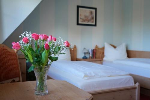 a vase of flowers on a table in a bedroom at Corso in Kühlungsborn