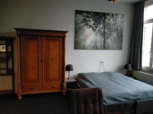 a bedroom with a bed and a large painting on the wall at Op de Burg in Venlo