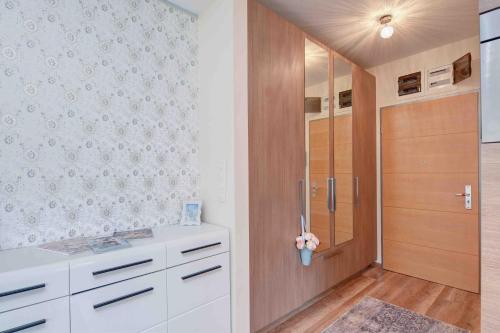 a kitchen with white cabinets and a wooden door at Madarhegy Apartment with garden Buda side in Budapest