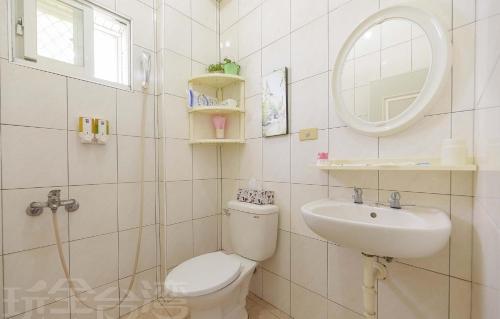 bagno con servizi igienici, lavandino e specchio di Yan Hai De Dai B&B a Magong