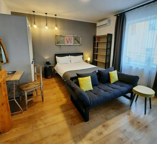 a living room with a bed and a couch at PIF Apartments Sadoveanu in Braşov