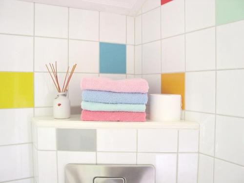 einen Stapel Handtücher auf einem Regal über einem Waschbecken in der Unterkunft B&B Hotel California in Wichmond