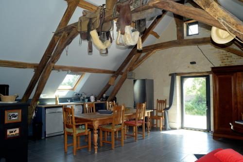 une cuisine et une salle à manger avec une table et des chaises en bois dans l'établissement Gîte familial La Tabarderie, à Courcelles-de-Touraine