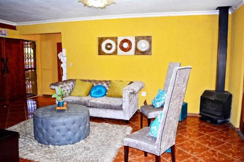 a living room with a couch and two chairs at MaU Bed and Breakfast in Krugersdorp
