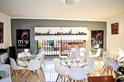 a dining room with white chairs and tables and a window at MaU Bed and Breakfast in Krugersdorp