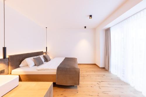 a bedroom with a bed and a large window at Max Mountain Apartments in Neustift im Stubaital