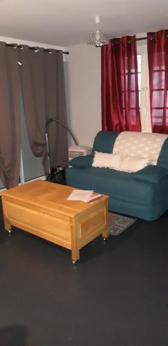 ein Wohnzimmer mit einem Bett und einem Couchtisch in der Unterkunft Loft dans les Vosges idéal 2 personnes in Le Thillot