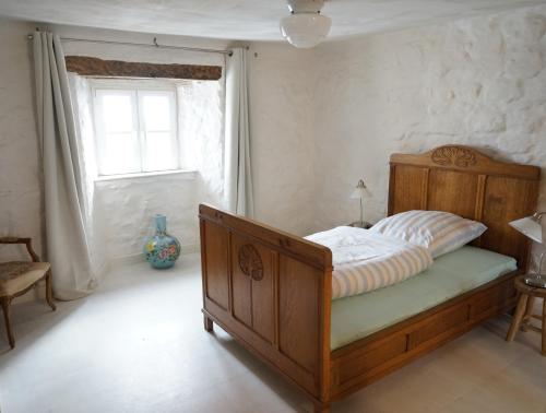 een slaapkamer met een houten bed en een raam bij House Kellisch 1822 in Steffeln