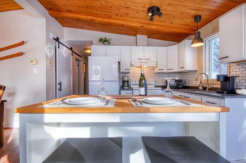 a kitchen with white cabinets and a wooden counter top at Chalet familial, très bien situé in Mont-Blanc