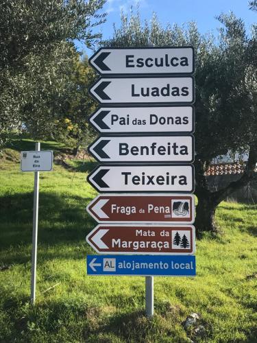 a street sign with many signs in a field at Casa da Travessa do Casal in Alqueve