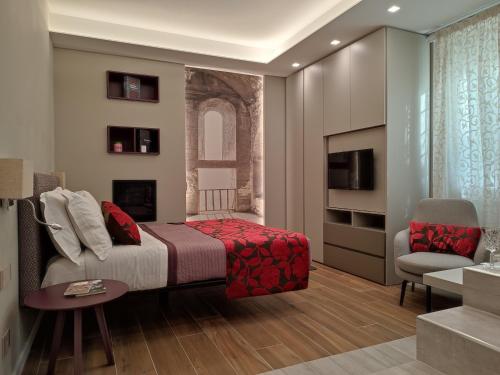 - une chambre avec un lit, une chaise et une télévision dans l'établissement il sogno di afrodite luxury b and b, à Rome