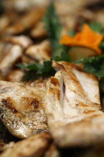a close up of a piece of chicken with a garnishment at Hotel Termal in Baile Felix