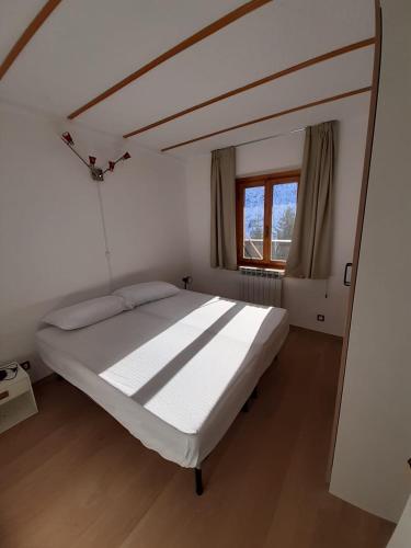 a large bed in a room with a window at Tonale 80 in Passo del Tonale