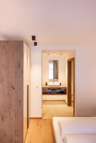 a bedroom with white walls and a mirror at Max Mountain Apartments in Neustift im Stubaital