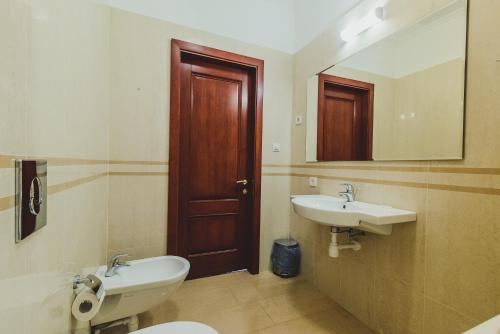 een badkamer met een wastafel, een toilet en een spiegel bij Ligo Morskaya in Simeiz