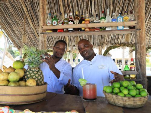 two men standing in front of a table with a pineapple at Cristal Resort in Paje