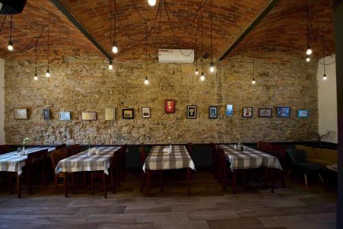 a dining room with tables and chairs and a brick wall at Pokoje Gościnne u Klimosza in Pogwizdów