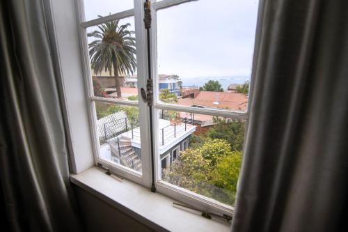 a window with a view of a palm tree at New Voga Hotel Boutique in Valparaíso