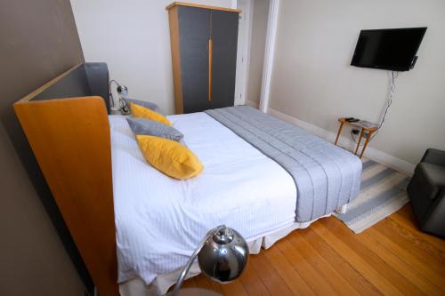 a bedroom with a large bed with yellow pillows at New Voga Hotel Boutique in Valparaíso