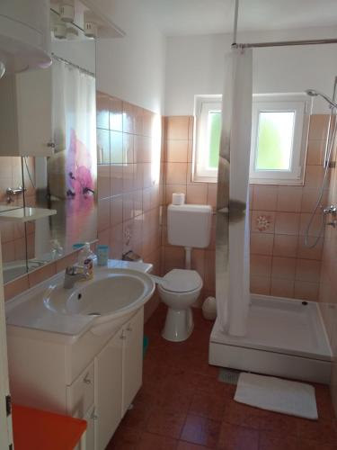 a bathroom with a sink and a toilet and a shower at Apartments Picolo Paradiso Miljenko Debelić in Rab