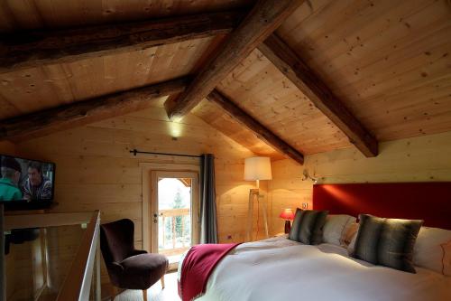 a bedroom with a bed in a room with wooden walls at Hôtel La Ferme du Chozal, Chalet de tradition in Hauteluce