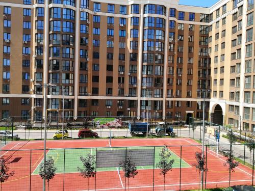 a tennis court in front of a large building at 0102 квартира в Софія Резиденс, 5 поверх in Vyshneve