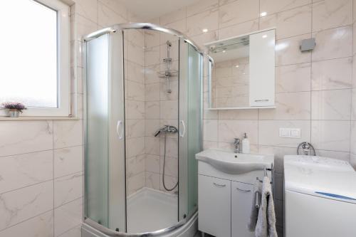 La salle de bains est pourvue d'une douche et d'un lavabo. dans l'établissement Amarillo Apartments, à Mlini