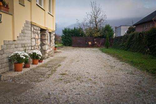 a dirt road next to a house with potted plants at Slovakia; space, tranquility and plenty of opportunities! Be welcome in Strawberry House! in Brzotín