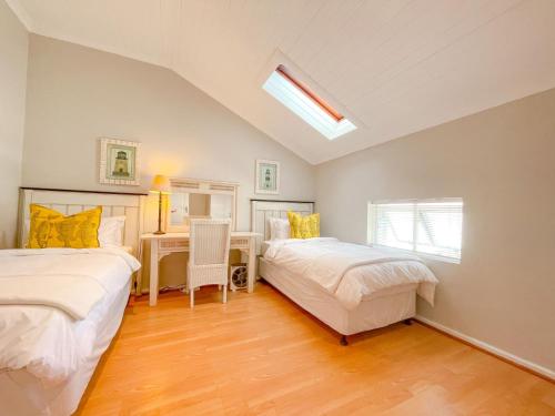 a bedroom with two beds and a desk in it at Sea-Lets in Keurboomstrand