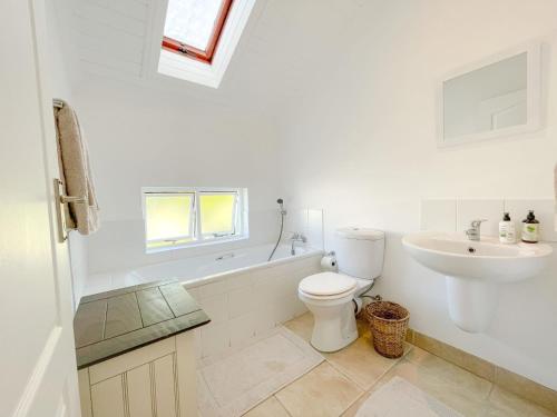 a white bathroom with a toilet and a sink at Sea-Lets in Keurboomstrand