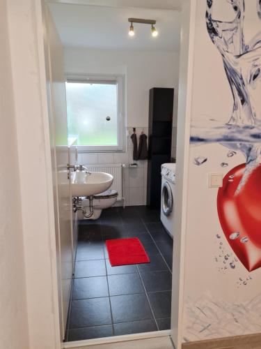 a bathroom with a sink and a washing machine at Ferienwohnung / Messeunterkunft in Willich