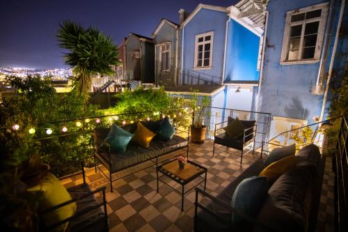 a patio with a couch and chairs on a balcony at night at New Voga Hotel Boutique in Valparaíso