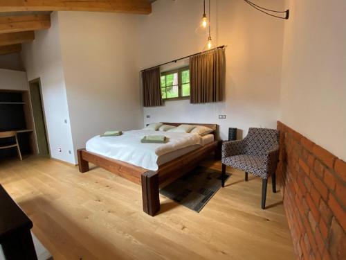 a bedroom with a bed and a chair and a window at Penzion Stodola in Weisswasser in Böhmen