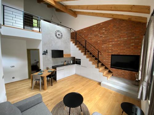 a living room with a staircase and a brick wall at Penzion Stodola in Weisswasser in Böhmen