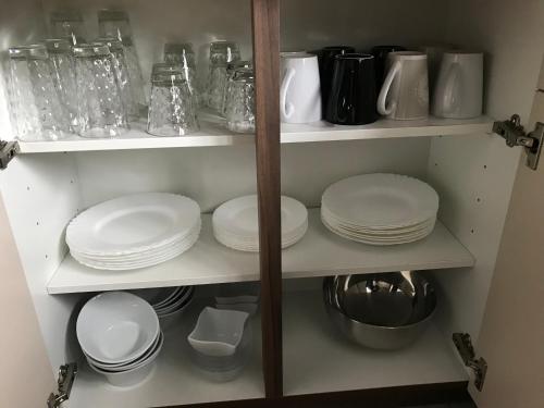 a shelf with plates and other dishes in a kitchen at Franzi‘s-Ferien-Freizeit in Peißenberg