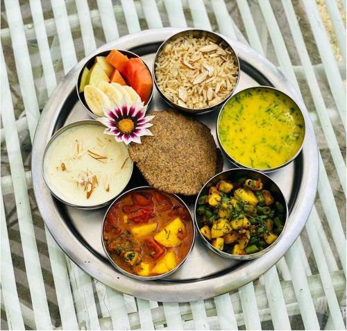 a plate of different types of food on a table at Yog Niketan By Sanskriti in Rishīkesh