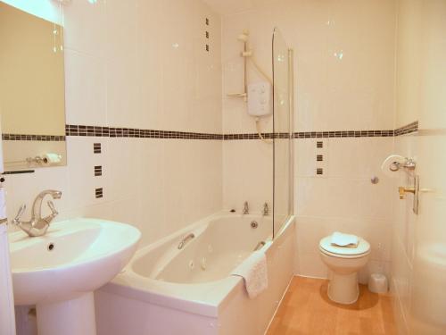 uma casa de banho com uma banheira, um WC e um lavatório. em Royal Mile, Edinburgh - 2 Bedroom Apartment em Edimburgo