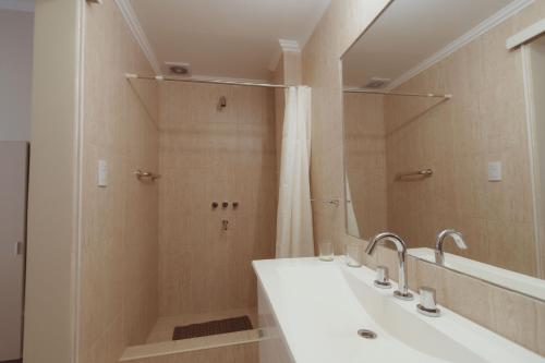 a bathroom with a sink and a shower with a mirror at Hotel Tonight in Salta