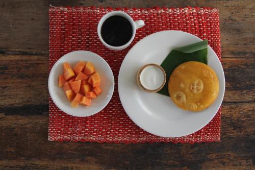 a table with two plates of food and a cup of coffee at Mar Amar Casa de Playa in Coveñas