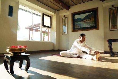 a man sitting on the floor in a room at Yog Niketan By Sanskriti in Rishīkesh