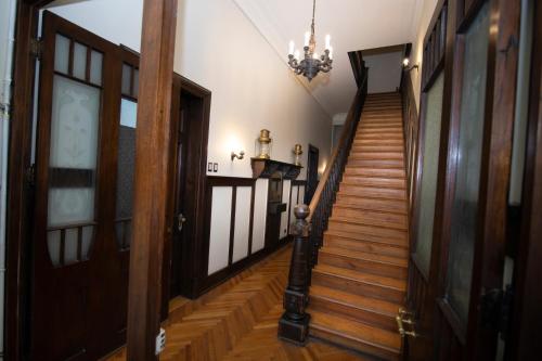 a hallway with wooden stairs and a chandelier at New Voga Hotel Boutique in Valparaíso