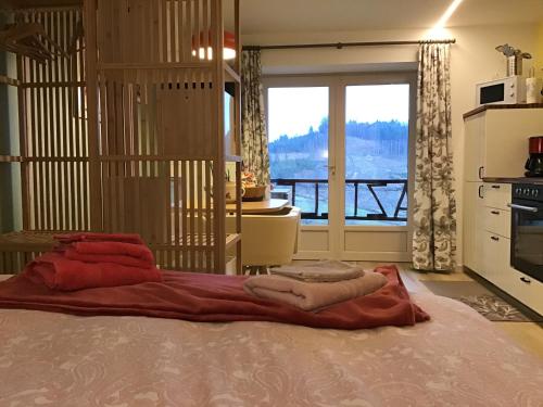 1 dormitorio con 1 cama y vistas a un balcón en La Mazille , cossy vakantiestudio met zwembad in zuid-Bourgogne, en Anglure-sous-Dun