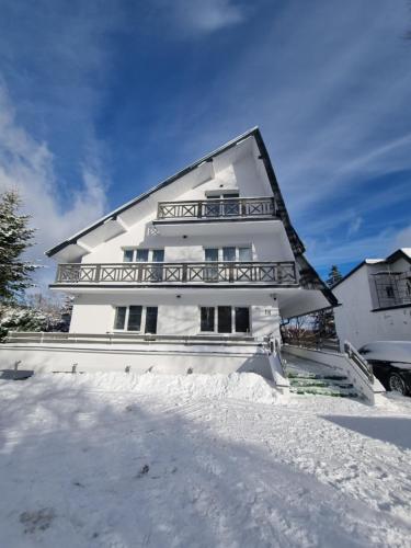 a white house with snow in front of it at Snow Queen in Szklarska Poręba